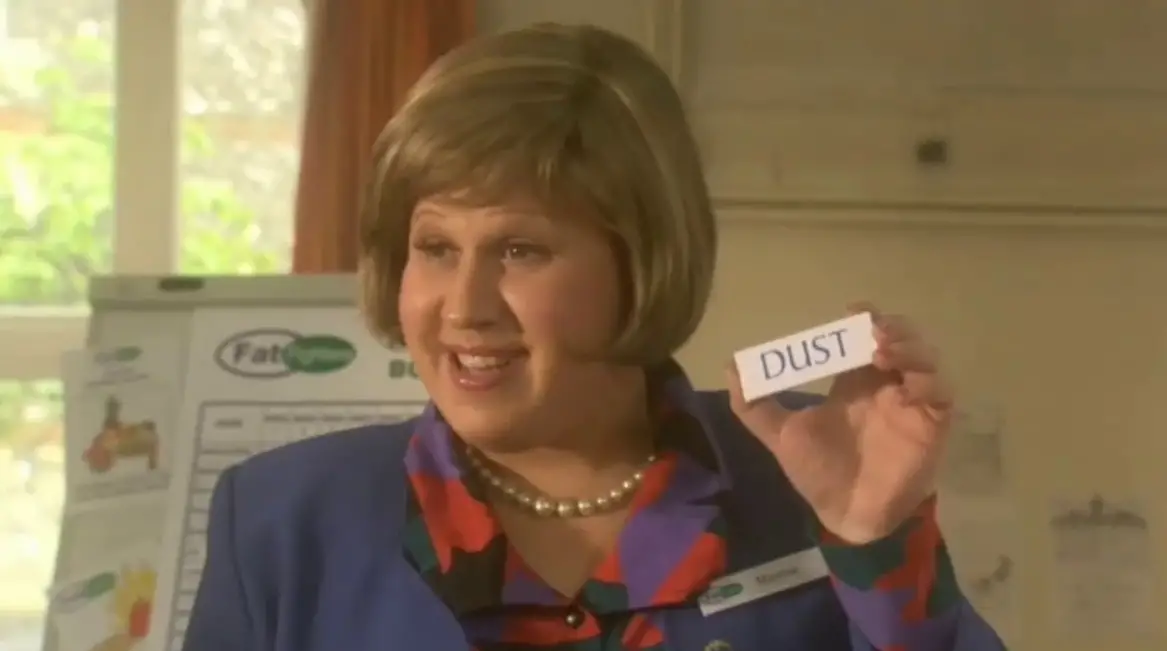 Woman holding up a "Dust" sign - from Little Britain